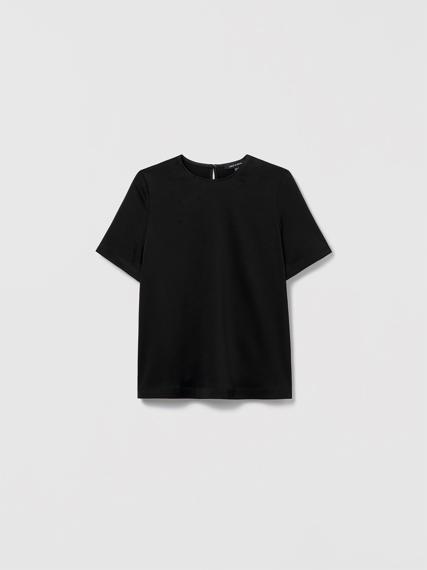 Black short-sleeve crew neck blouse in satin back crepe by Judith & Charles featuring a boxy silhouette and back keyhole button closure. Unlined, 25-inch back length. Made in Canada with Japanese fabric.